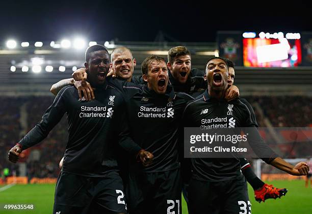 Divock Origi of Liverpool celebrates with team mates Lucas Leiva and Jordon Ibe as he scores their fourth goal during the Capital One Cup quarter...