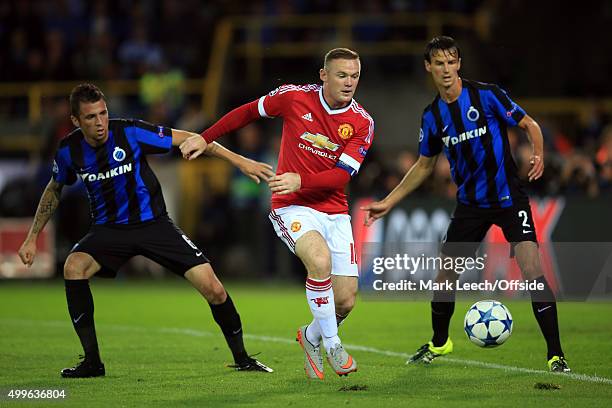 Wayne Rooney of Manchester United in action with Davy De Fauw and Claudemir of Club Brugge during the UEFA Champions League Qualifying Round Play Off...
