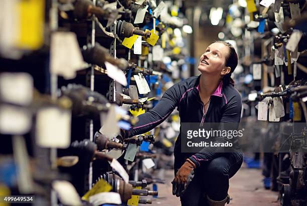 female mechanic working at storage - junkyard stockfoto's en -beelden