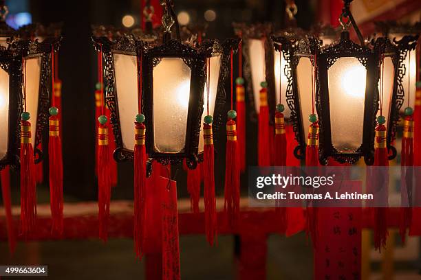 several lit lanterns hanging at the man mo temple in hong kong, china. - templo de man mo - fotografias e filmes do acervo