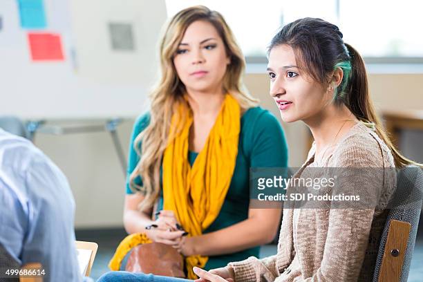 trendy college età donne discutendo qualcosa in classe o terapia - alternative therapy foto e immagini stock