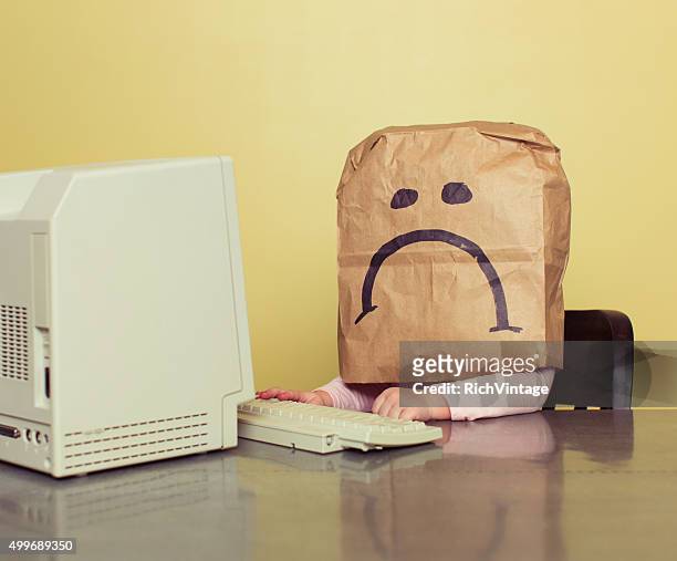 young girl in front of computer with brown bag frown - rich fury stock pictures, royalty-free photos & images