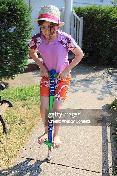 adolescent girl playing on pogo stick - pogo stock-fotos und bilder