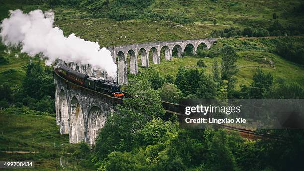 jacobite express crossing glenfinnan viaduct - glenfinnan viaduct scotland stock pictures, royalty-free photos & images