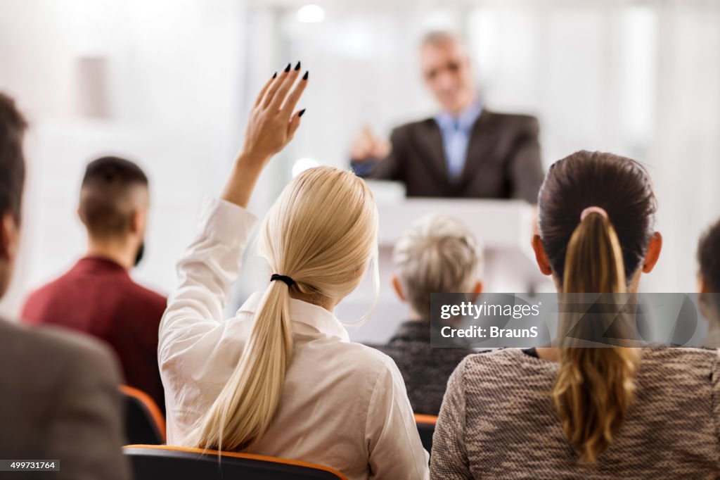 Back view of a businesswoman asking a question.