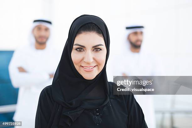 beautiful arabian woman with two arab men standing behind - middle east cool stock pictures, royalty-free photos & images