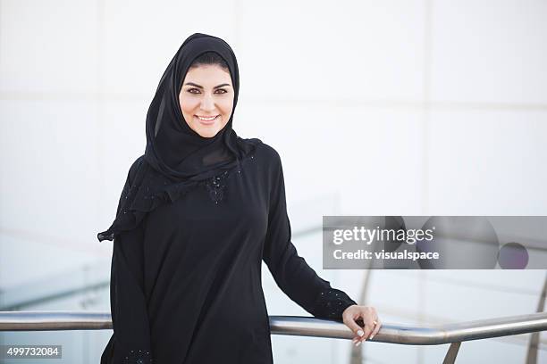 exitosa mujer de negocios árabe fuera del edificio de oficinas - emirati face smile fotografías e imágenes de stock