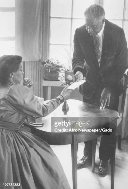 Married African-American actors and activists Ruby Dee and Ossie Davis exchanging a letter at a table, 1970.