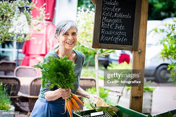 lachen weiblichen markt händler am marktstand mit bio-speisen - marktstand stock-fotos und bilder