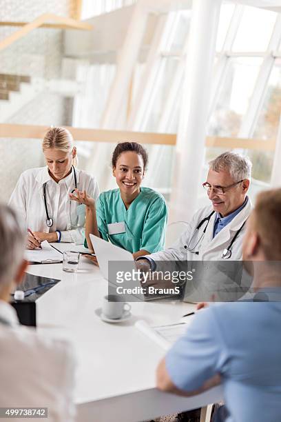 multi-tasking healthcare workers working at doctor's office in the hospital. - hospital teamwork stock pictures, royalty-free photos & images