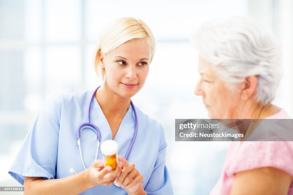 Doctor Discussing Medication With Female Patient In Hospital