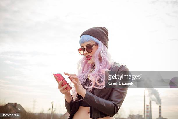 outdoor portrait of blue-pink hair cool girl texting on phone - hip body part 個照片及圖片檔