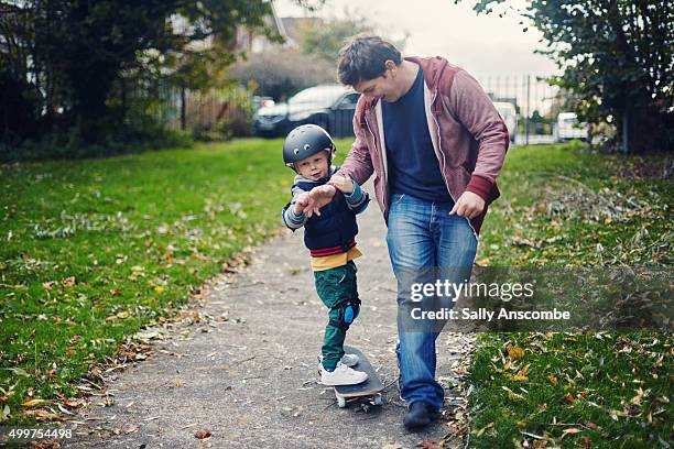 child learning to skateboard - lean in collection father stock pictures, royalty-free photos & images