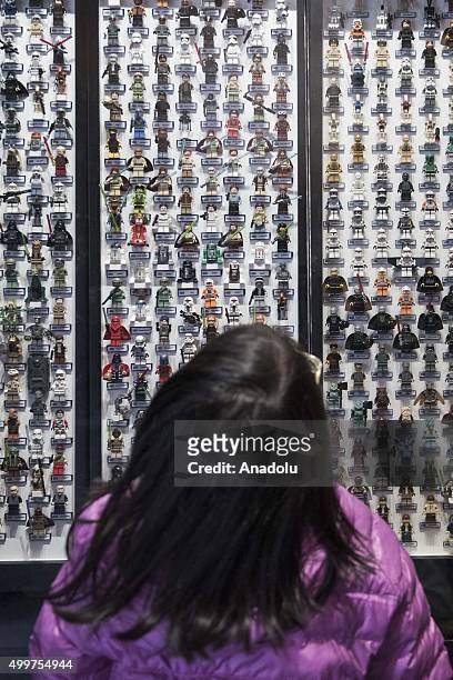 Young girl looks at Star Wars figures displayed outside a shopping mall ahead of the release of the film in Hong Kong on December 3, 2015. The new...