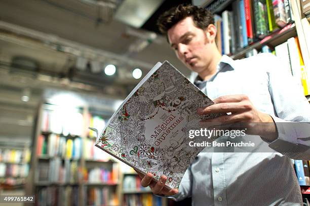 An employee reads a copy of "The Magical Christmas" colouring book in Foyles bookshop on December 3, 2015 in London, United Kingdom. Foyles flagship...