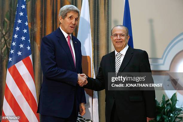 Cypriot Foreign Minister Ioannis Kasoulides shakes hands with US Secretary of State John Kerry during their meeting in Nicosia on December 3, 2015....