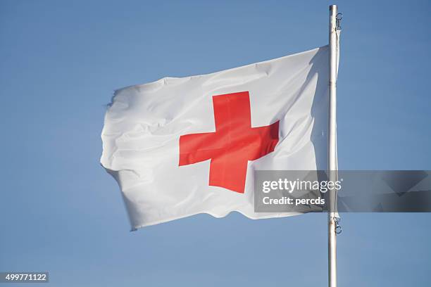 first aid/medic red cross flag and blue sky. - rött kors bildbanksfoton och bilder