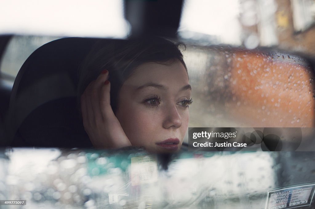 Woman's face seen in the rear mirror of a car