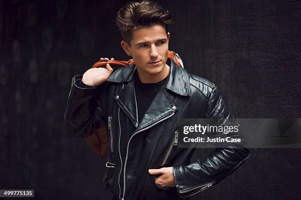 stylish man carrying a leather bag - man leather jacket stock pictures, royalty-free photos & images