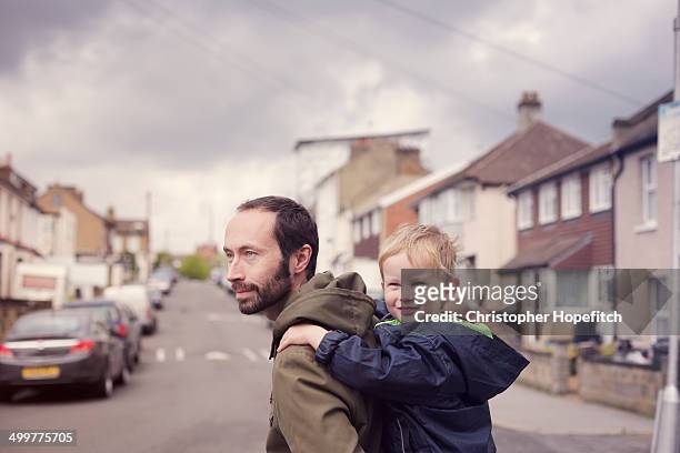 father and son on school run - piggy back stock pictures, royalty-free photos & images