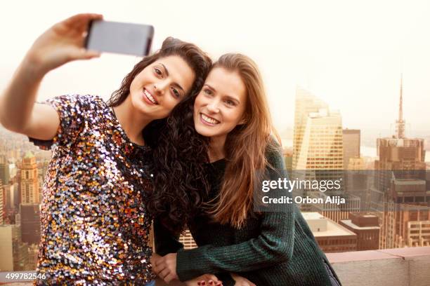women taking a selfie on rooftop - new york vacation rooftop stock pictures, royalty-free photos & images
