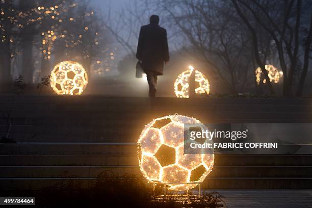 Man walks past Christmas decorations as he leaves the FIFA headquarters on December 3, 2015 in Zurich. The unprecedented corruption scandal engulfing...