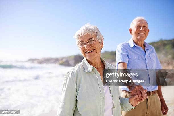 hanno uno spirito avventuroso - couple walking on beach foto e immagini stock