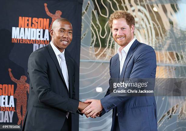 Prince Harry shakes the hand of Nelson Mandela's grandson, Mbuso Mandela at the Nelson Mandela Foundation Centre of Memory on December 3, 2015 in...