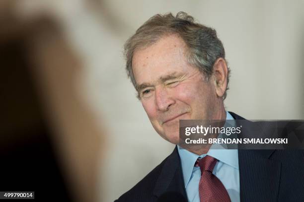 Former US President George W. Bush winks on December 3 during a dedication ceremony hosted by the US Senate at Emancipation Hall of the US Capitol...