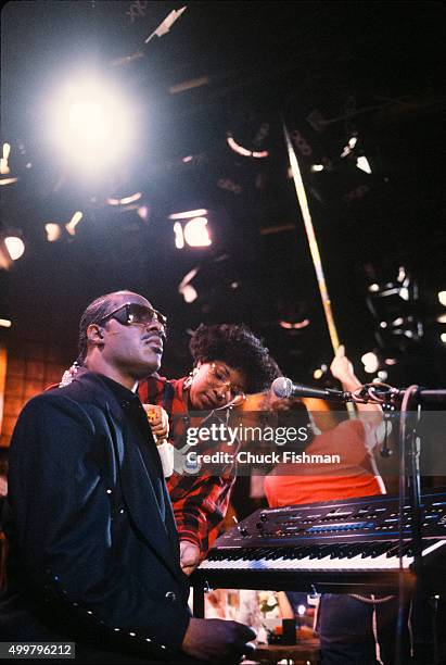 As a wardrobe specialist adjusts his jacket, American Jazz and Pop musician Stevie Wonder sits a piano on the set of the television soap opera 'All...