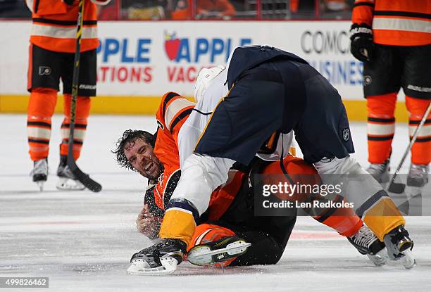 Colin McDonald of the Philadelphia Flyers is tackled to the ice by Barret Jackman of the Nashville Predators on November 27, 2015 at the Wells Fargo...