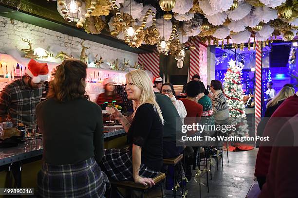 Karen Kaplan, left, and Tammy Merritt, left center, spend time at the holiday themed bar, Miracle on Seventh Street on Tuesday December 01, 2015 in...