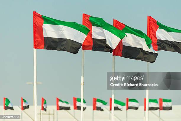 row of flags of the united arab emirates - emirates flag stock-fotos und bilder