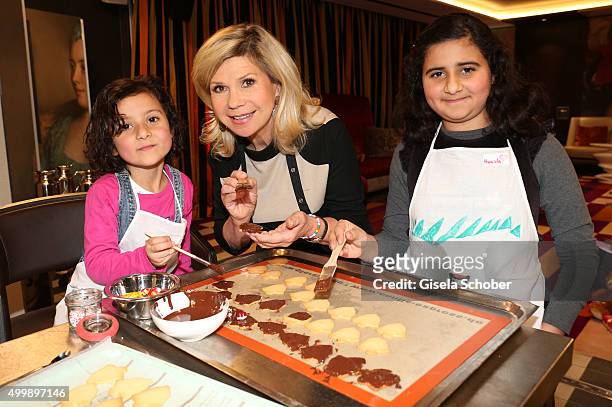 Marianne Hartl prepares cookies with children during the World Childhood Foundation Baking at Hotel Vier Jahreszeiten on November 30, 2015 in Munich,...