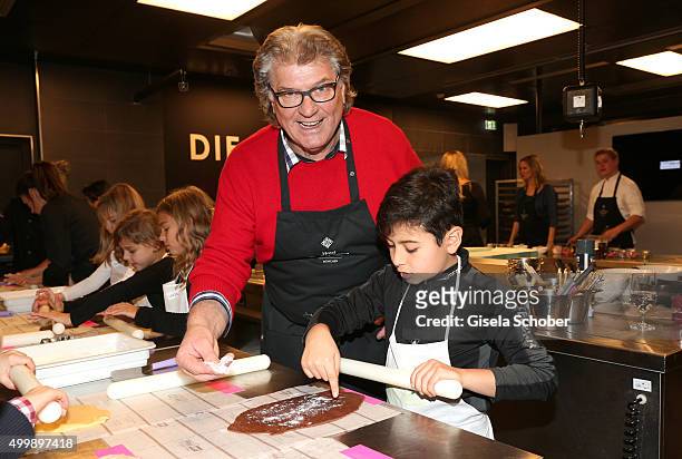 Michael Hartl prepares cookies with a boy during the World Childhood Foundation Baking at Hotel Vier Jahreszeiten on November 30, 2015 in Munich,...