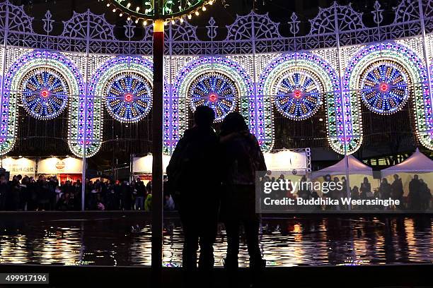 Couple stands as enjoy an illuminated structure surrounding a fountain as a part of the 21th Kobe Luminarie on December 4, 2015 in Kobe, Japan. This...