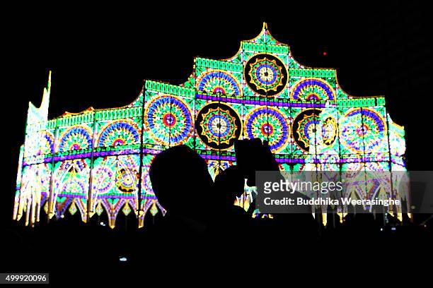Man uses his smart phone and take picture under an illuminated structure as a part of the 21th Kobe Luminarie on December 4, 2015 in Kobe, Japan....