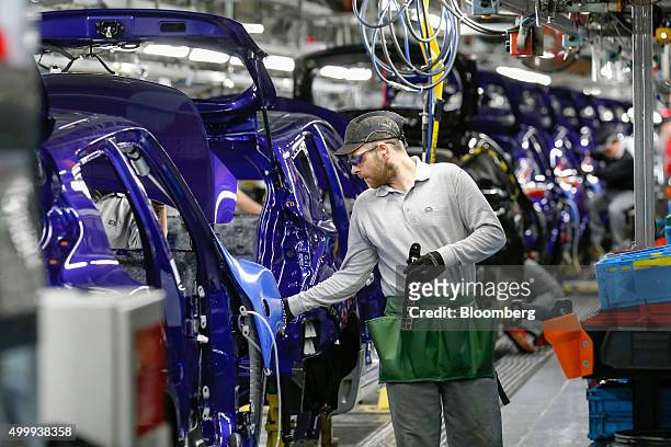 An employee adjusts a Nissan Juke on the production line at the Nissan Motor Co. Production plant in Sunderland, U.K., on Thursday, Dec. 3, 2015....