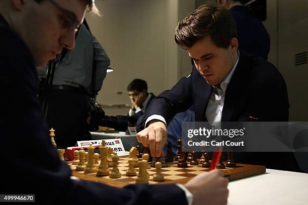 World chess champion Magnus Carlsen makes a move against Maxime Vachier-Lagrave in an opening game at the London Chess Classic tournament on December...