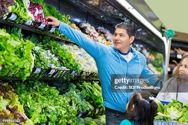 hispanic father shopping for healthy food with young daughters - sports clothing retail stock pictures, royalty-free photos & images