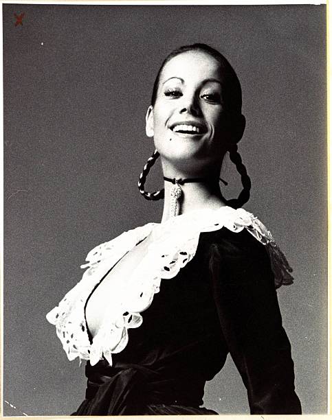 French actress Claudine Auger wearing an Oscar de la Renta evening dress with plunging neckline and white lace collar; velvet ribbon choker with...