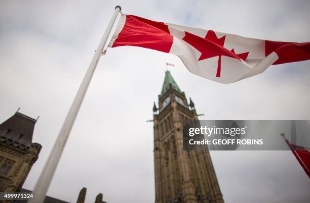 Canadian flag flies in front of the peace tower on Parliament Hill in Ottawa, Canada on December 4 as part of the ceremonies to the start Canada's...