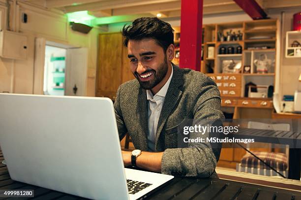 lächelnd mann mit laptop - workoholic stock-fotos und bilder