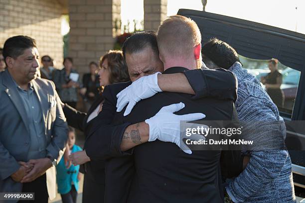 Tim Mraz, boyfriend of Paris attack victim Nohemi Gonzalez, hugs a fellow pallbearer during funeral services on December 4, 2015 in Downy,...