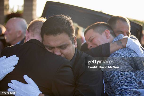 Tim Mraz , boyfriend of Paris attack victim Nohemi Gonzalez, and three other pallbearers hug after carrying her casket from funeral services on...