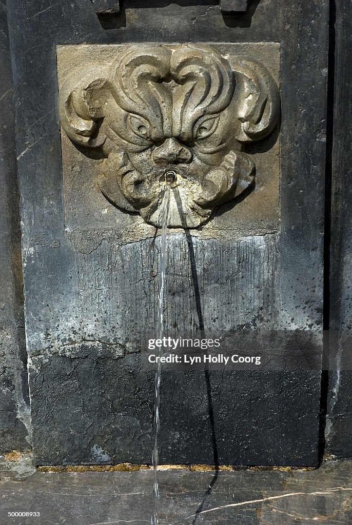 Stone carved water fountain spouting water