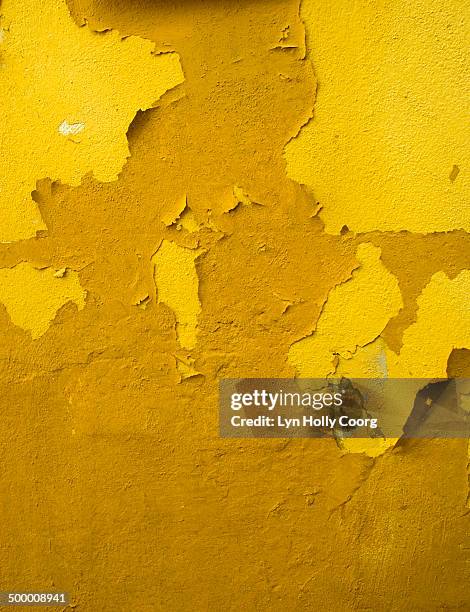 old yellow wall with peeling paint - lyn holly coorg stockfoto's en -beelden