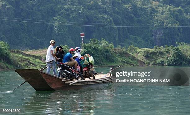 This picture taken on December 1, 2015 shows local residents crossing a river on a boat at the national park Phong Nha - Ke Bang in the central...