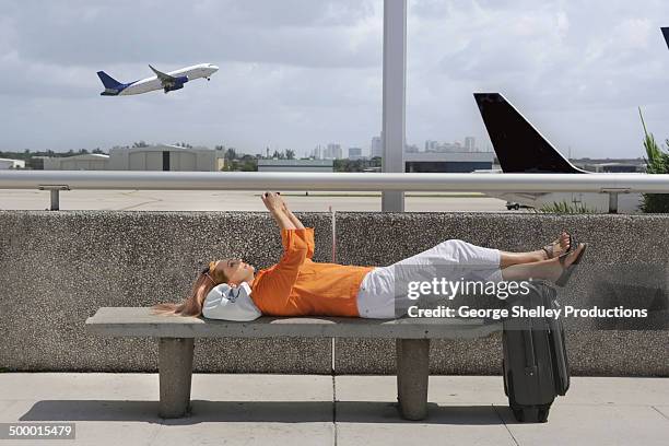 woman works on smartphone between flights - jet lag stockfoto's en -beelden