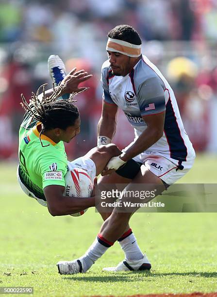 Justin Geduld of South Africa is tackled by Folau Niua of the USA in the Cup quarter final match during the Emirates Dubai Rugby Sevens - HSBC World...